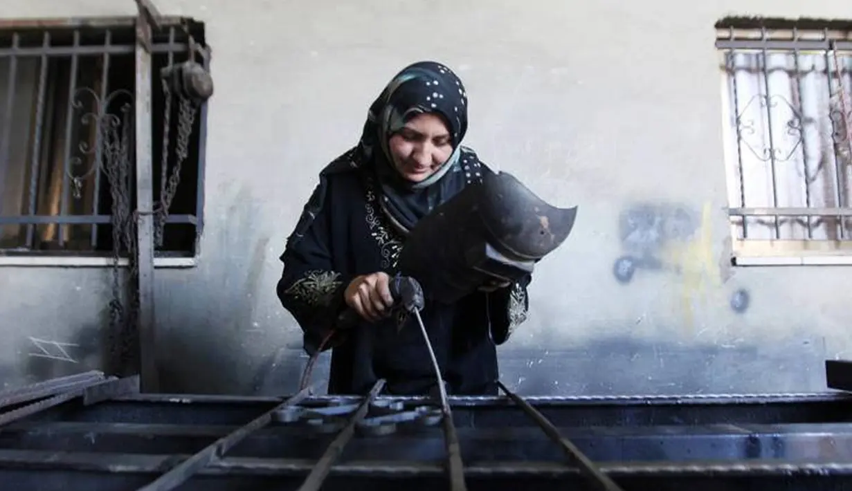 Wanita Palestina, Ranim Safadi menyelesaikan pembuatan pagar besi di sebuah bengkel keluarga di desa Urif, wilayah Tepi Barat, Senin (31/10). Ranim memilih bekerja sebagai pandai besi agar dapat membantu keuangan keluarga (facebook.com/estrellapalestina)