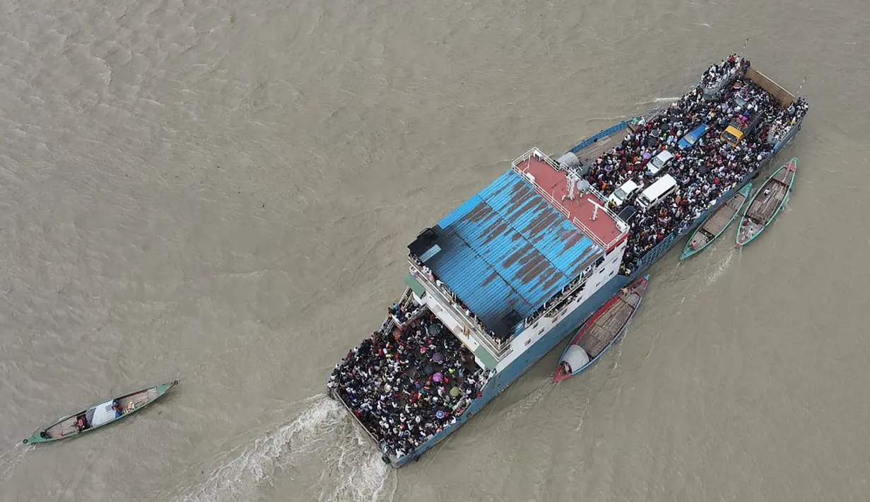 Foto udara yang diambil pada 27 Juni 2021 ini memperlihatkan sebuah kapal feri yang penuh dengan penumpang di Munshiganj, Bangladesh. Peningkatan kasus COVID-19 telah mendorong pemerintah Bangladesh untuk memperketat pembatasan secara bertahap. (Munir Uz zaman/AFP)