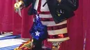 Patung emas mantan presiden Donald Trump yang dipajang pada Konferensi Politik Konservatif (CPAC) di Orlando, Florida, Jumat (26/2/2021). Patung tersebut dalam balutan jas setelan merek dagang Trump dengan celana pendek bertema bendera Amerika, dan sandal jepit. (AP Photo / John Raoux)