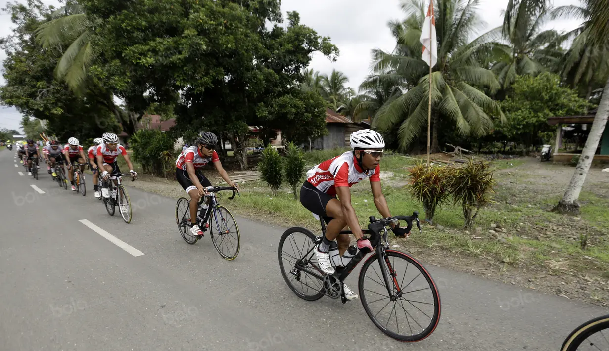 Tim Indonesia  melewati halaman rumah warga yang memajang bendera Merah-Putih menyambut HUT RI ke-71 pada ajang balapa Tour de Singkarak 2016 di Sumatera Barat, (11/8/2016). (Bola.com/Nicklas Hanoatubun)