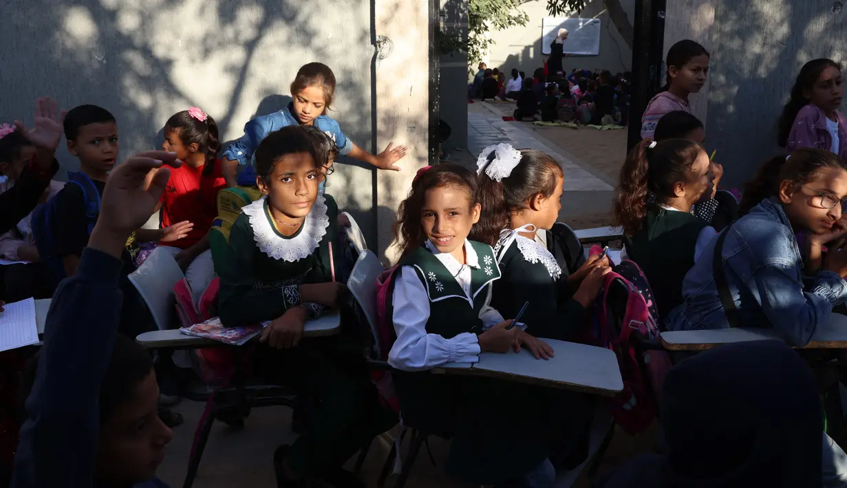 Anak-anak pengungsi Palestina menghadiri kelas di sebuah sekolah darurat di Khan Yunis di Jalur Gaza selatan pada 20 Oktober 2024. (BASHAR TALEB/AFP)