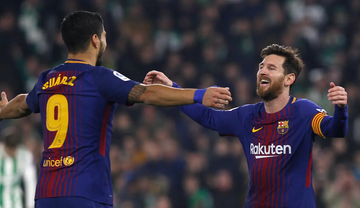 Pemain Barcelona, Lionel Messi dan rekan setimnya Luis Suarez merayakan gol ke gawang Real Betis pada pertandingan lanjutan La Liga di Stadion Benito Villamarin, Minggu (21/1). Barcelona menang telak 5-0 atas tuan rumah Real Betis. (AP/Miguel Morenatti)