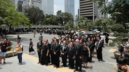 Pengacara berkumpul selama saat berdemonstrasi di Hong Kong, Rabu (7/8/2019). Para pengacara mengenakan jas berwarna hitam senada dengan gerakan massa prodemokrasi. (AP Photo/Kin Cheung)