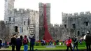 Sejumlah pengunjung melihat karya seni 'Jendela Menangis' di Caernarfon Castle karya seniman Paul Cummins dan desainer Tom Piper, Wales, Senin (17/10). (REUTERS / Rebecca Naden)