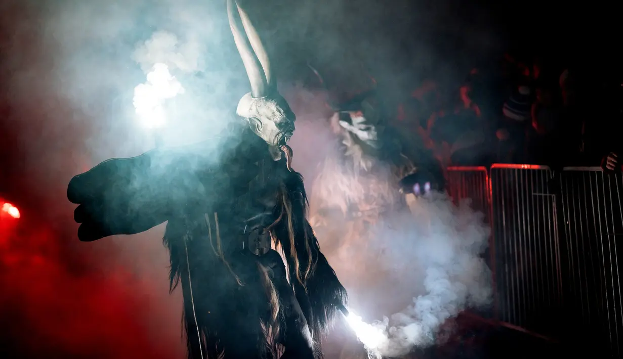 Partisipan berpakaian seperti Krampus, makhluk setengah iblis, saat ambil bagian dalam parade di kota Podkoren, Slovenia, Jumat (30/11). Parade bagian dari tradisi natal itu menghadirkan sosok Krampus untuk menakuti anak-anak yang nakal (Jure Makovec/AFP)