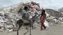 Seorang anak laki-laki menaiki kuda saat mengumpulkan sampah untuk didaur ulang di tempat pembuangan sampah di kota Houdieda, Yaman, Rabu (20/1). (REUTERS/Abduljabbar Zeyad)