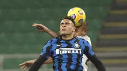 Penyerang Inter Milan, Lautaro Martinez berebut bola udara dengan pemain Bologna, Danilo Larangeira pada pertandingan lanjutan Liga Serie A Italia di Stadion San Siro Milan, Minggu (6/12/2020). Inter menang 3-1 atas Bologna. (AP Photo/Antonio Calanni)