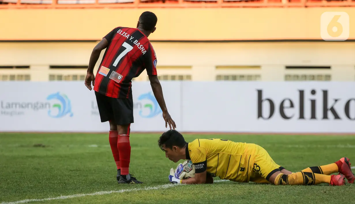 Kiper Persela Dwi Kuswanto (bawah) berusaha menyelamatkan bola dari gelandang Persipura Elisa Yahya Basna dalam laga pekan kedua BRI Liga 1 2021/2022 antara Persela Lamongan melawan Persipura Jayapura di Stadion Wibawa Mukti, Cikarang, Jumat (10/9/2021). (Bola.com/Bagaskara Lazuardi)