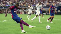 Striker Barcelona, Ousmane Dembele melepaskan tendangan yang menghasilkan gol pertama ke gawang Real Madrid pada laga pramusim Soccer Champions Tour 2023 di AT&T Stadium, Arlington, Texas, Minggu (30/7/2023) dini hari WIB. (AP Photo/Jeffrey McWhorter)