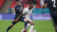 Pemain Skotlandia, Billy Gilmour mengadang pemain Timnas Inggris, Raheem Sterling pada matchday 2 Euro 2020. (CARL RECINE / POOL / AFP)