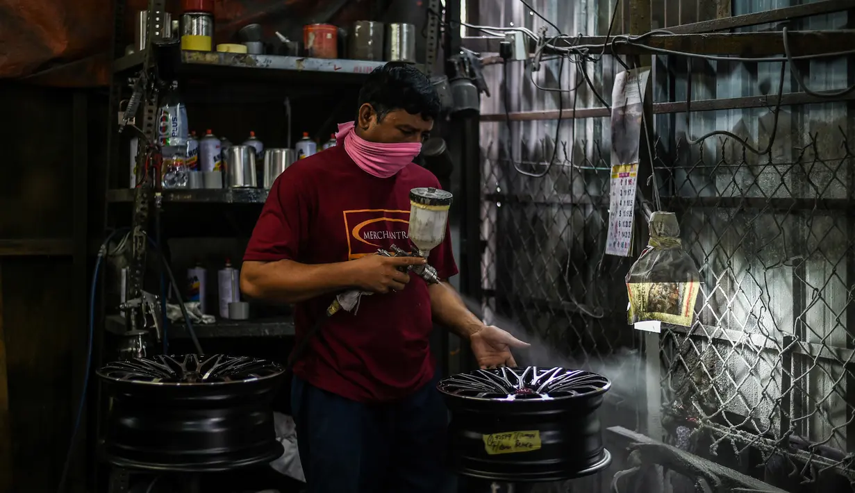 Pekerja menyemprotkan pelek di sebuah bengkel di Ampang, di pinggiran kota Kuala Lumpur, Malaysia (18/7). (AFP Photo/Mohd Rasfan)