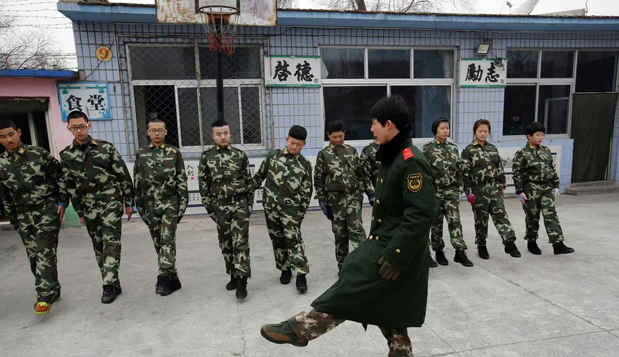 Seorang mantan anggota militer Tiongkok mengajarkan baris berbaris di Pusat Pendidikan Qide, Beijing, 19/2/2014. Pusat Pendidikan Qide merupakan sebuah camp bergaya militer yang menawarkan pengobatan untuk para pecandu internet. (REUTERS/Kim Kyung-Hoon)
