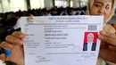 Peserta menunjukkan kartu ujian CPNS Kementerian Kelautan dan Perikanan (KKP) di Jakarta, Minggu (8/10). Pembukaan lowongan CPNS ini dalam rangka mengisi kekosongan 41 jabatan pada Kantor Pusat dan UPT di KKP. (Liputan6.com/Johan Tallo)