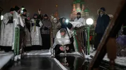Ribuan pengikut Gereja Ortodoks Rusia terjun ke sungai dan kolam es di seluruh negeri untuk menandai Epiphany, pembersihan diri mereka dengan air yang dianggap suci untuk hari itu. (AP Photo/Alexander Zemlianichenko)