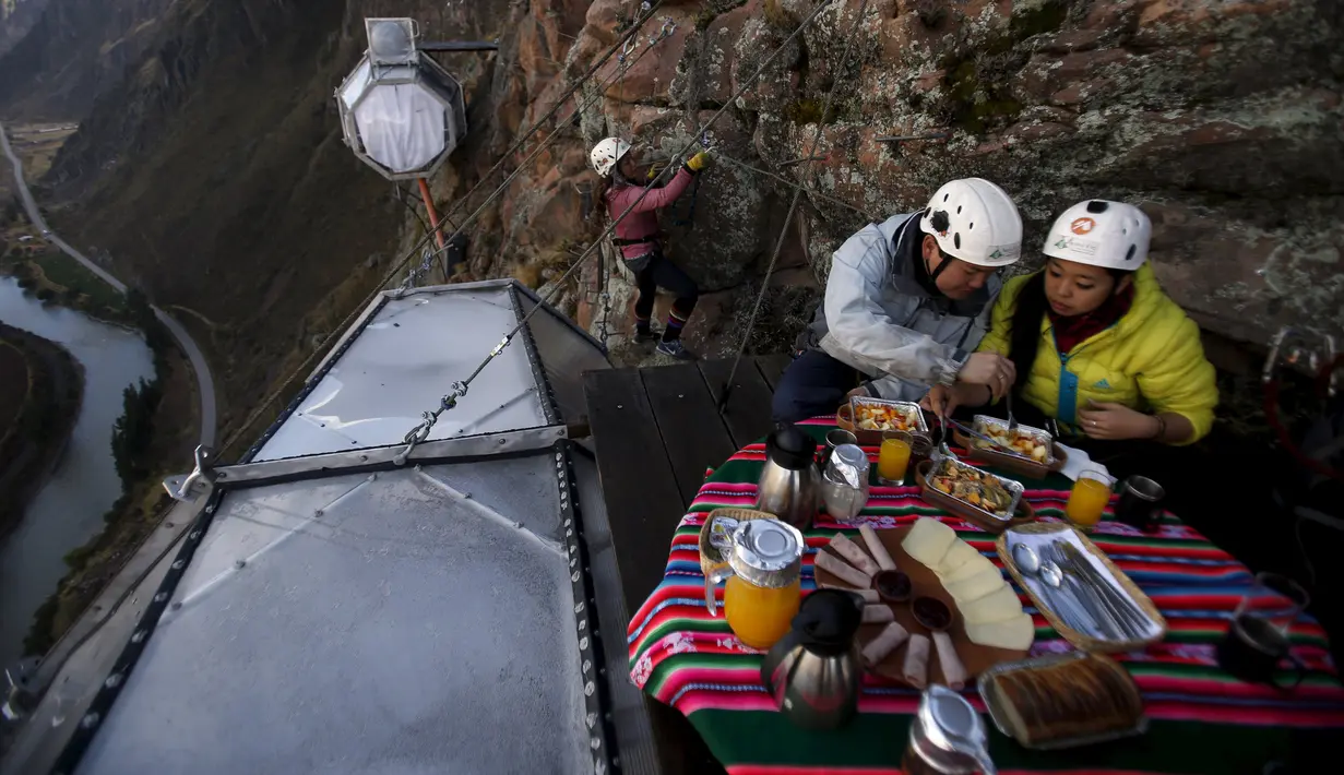 Pengunjung menikmati sarapan di atas kapsul tidur di Skylodge Adventure Suites di Lembah Suci di Cuzco, Peru, 14 Agustus 2015. Hotel  tergantung dengan ketinggian 400 meter ini memiliki tarif sekitar Rp 4 juta per malam. (REUTERS/Pilar Olivares)
