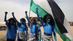 Warga Palestina bergaya seperti karakter dari film "Avatar" mengibarkan bendera selama protes menuntut hak untuk kembali ke kampung halaman mereka di perbatasan Israel-Gaza, Timur Khan Yunis di Gaza selatan Strip, (4/5). (AFP Photo/Said Khatib)