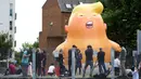 Aktivis mengembangkan balon bayi Presiden AS Donald Trump di London, 10 Juli 2018. Kemunculan balon berpopok itu mungkin bisa memperburuk ketegangan antara Wali Kota Sadiq Khan dan Trump, yang sebelumnya saling cibir di Twitter. (AFP/Isabel INFANTES)