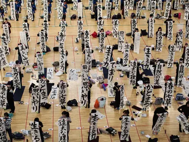 Peserta menunjukkan tulisan Jepang mereka saat mengikuti lomba kaligrafi Tokyo, Jepang (5/1). Lomba kaligrafi tulisan Jepang ini digelar setiap tahun yang diadakan pada awal tahun baru. (AFP Photo/Behrouz Mehri)