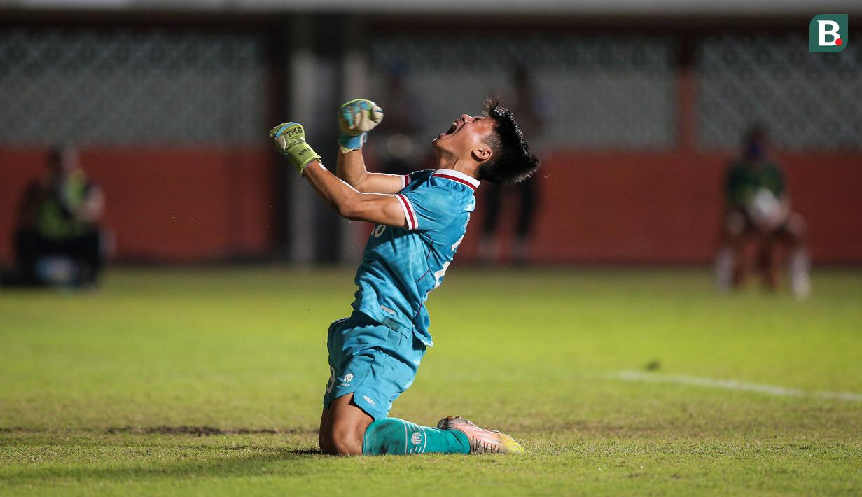 <p>Kiper Timnas Indonesia U-16, Andrika Fathir Rachman melakukan selebrasi usai menggagalkan tendangan pemain Myanmar saat adu penalti dalam laga semifinal Piala AFF U-16 2022 antara Indonesia U-16 melawan Myanmar U-16 di Stadion Maguwoharjo, Sleman, Rabu (10/8/2022) malam WIB. (Bola.com/Bagaskara Lazuardi)</p>