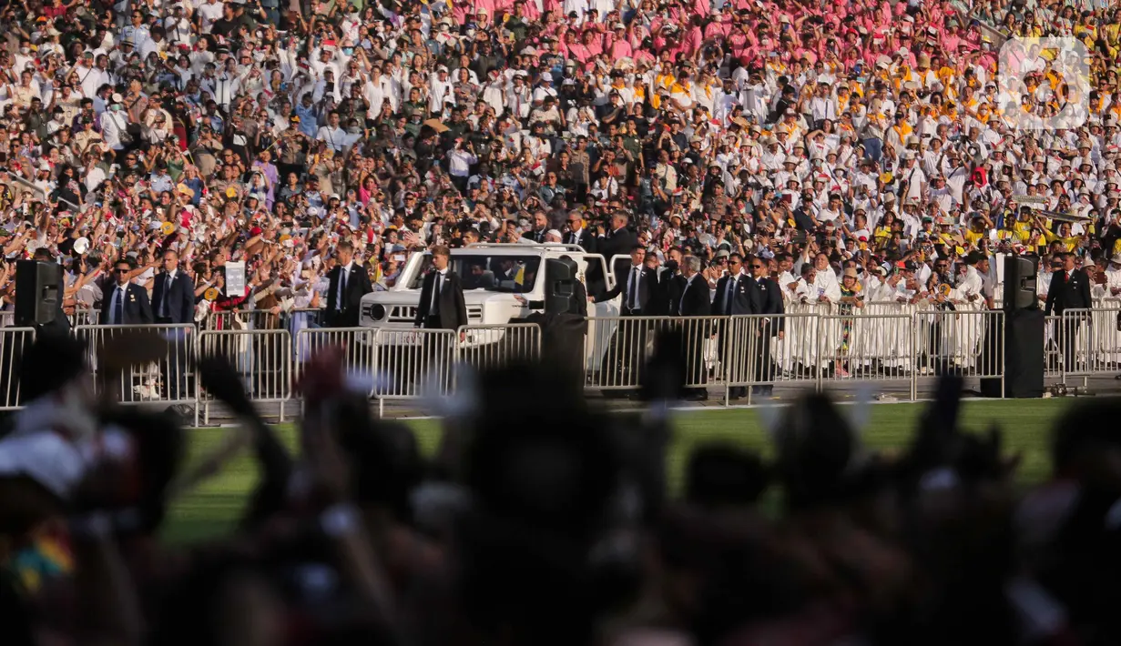 Menaiki mobil Maung buatan PT Pindad, Paus Fransiskus berkeliling menyapa umat yang tersebar di Stadion Utama Gelora Bung Karno. (Liputan6.com/Herman Zakharia)