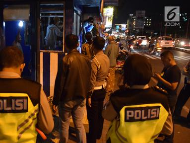 Polisi berjaga di pos polisi yang sedang diperbaiki usai dibakar massa saat peringatan Hari Buruh di Yogyakarta, Selasa (1/5) malam. Pos polisi ini terletak di pertigaan UIN Sunan Kalijaga Yogyakarta. (Liputan6.com/Gholib)