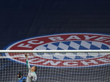 Kiper Bayern Munchen, Manuel Neuer memotong jaring gawang saat merayakan timnya meraih trofi Liga Champions usai mengalahkan PSG pada pertandingan final di stadion Luz di Lisbon (23/8/2020). Munchen menang tipis atas PSG 1-0. (AFP/Pool/David Ramos)