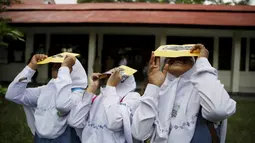 Sejumlah siswi mengunakan kacamata filter melihat matahari saat workshop bersama Hong Kong Astronomical Society dan LAPAN di sekolah di Ternate, (7/3). Kacamata ini akan digunakan untuk mengamati Gerhana Matahari Total. (REUTERS/Beawiharta)