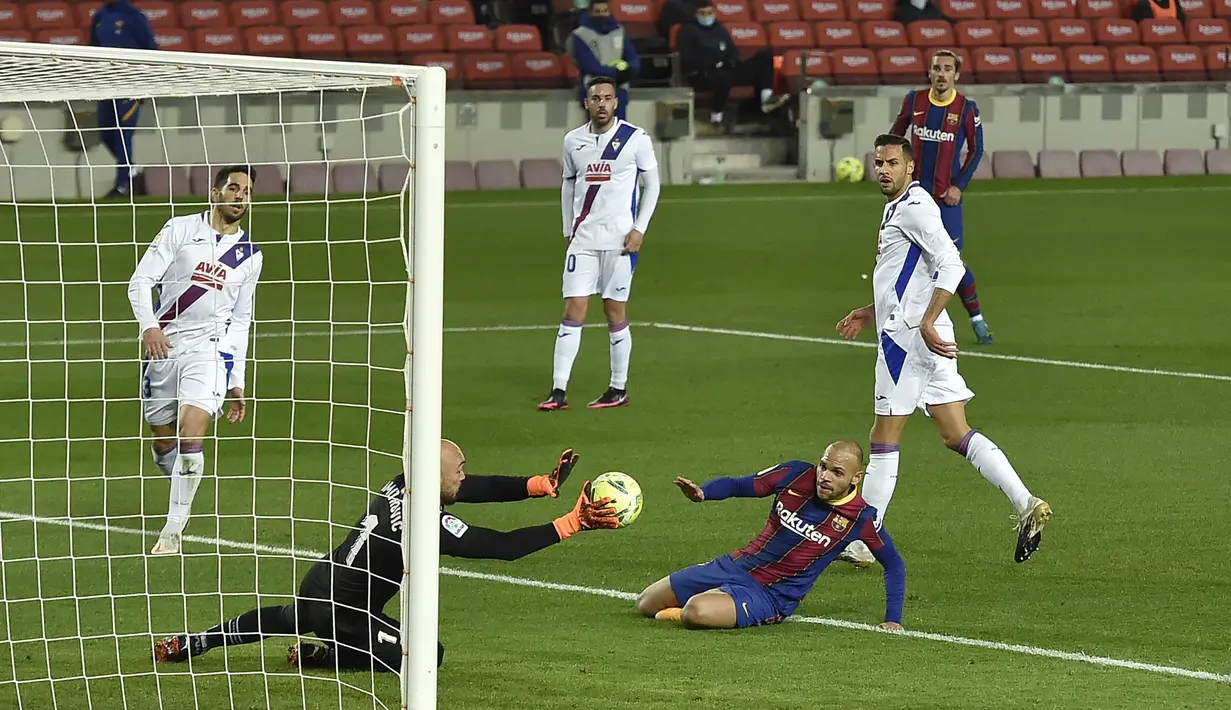 Kiper Eibar, Marko Dmitrovic (kiri) mementahkan tendangan striker Barcelona, Martin Braithwaite dalam laga lanjutan Liga Spanyol 2020/21 pekan ke-16 di Camp Nou, Selasa (29/12/2020). Eibar bermain imbang 1-1 dengan Barcelona. (AFP/Pau Barrena)