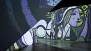 Seorang anggota staf menonton pratinjau pameran imersif Imagine Picasso, di mana lebih dari 200 karya Pablo Picasso diproyeksikan di layar dan struktur tiga dimensi, di Vancouver, British Columbia (26/10/2021). (Darryl Dyck/The Canadian Press via AP)