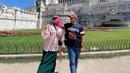 Berfoto bersama sang suami, Sheza Idris mengenakan kemeja pink dengan collar putih yang dipadukan midi skirt berwarna hijau. Lengkap dengan hijab berwarna pink dan sneakers. (instagram/shezaidris)