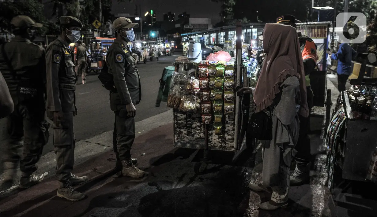 Petugas Satpol PP menertibkan pedagang di kawasan Kota Tua, Jakarta, Kamis (31/12/2020). Penertiban tersebut dilakukan guna mencegah kerumunan seiring larangan bagi warga merayakan malam Tahun Baru di Kota Tua di tengah pandemi COVID-19. (merdeka.com/Iqbal S. Nugroho)