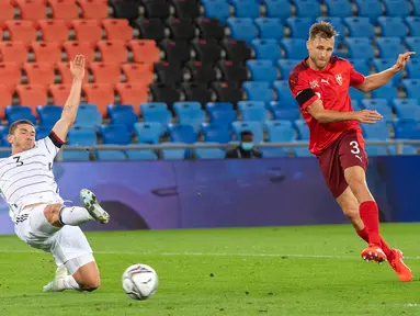 Bek Timnas Swiss, Silvan Widmer mencetak gol melewati Robin Gosens dari Jerman pada pertandingan kedua Liga A Grup 4 UEFA Nations League di St Jakob Park, Senin (7/9/2020) dini hari. Sementara itu Jerman dipaksa bermain imbang 1-1 oleh tuan rumah Swiss. (Georgios Kefalas/Keystone via AP)