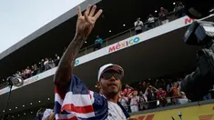 Pembalap asal Inggris dari tim Marcedes, Lewis Hamilton merayakan kemenangannya meraih juara dunia F1 untuk yang ke empat kalinya di Autodromo Hermanos Rodrigue, Meksiko (29/10). (AP Photo / Rebecca Blackwell)