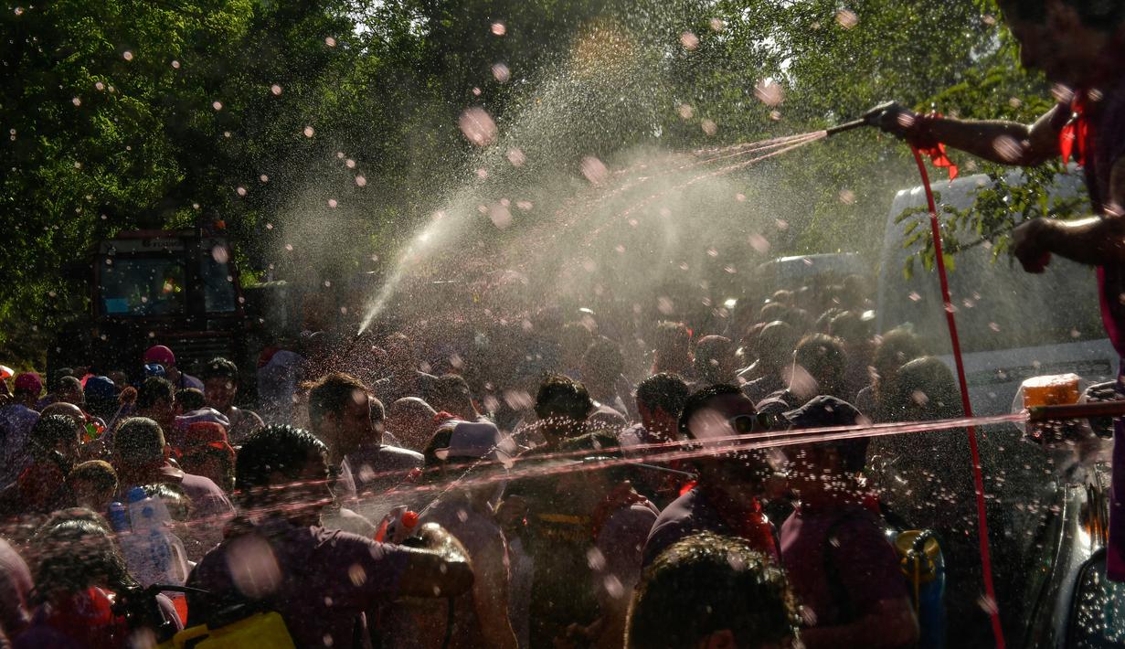 Peserta diguyur anggur merah saat ambil bagian dalam perang anggur di Haro, Spanyol utara, Sabtu (29/6/2019). Ratusan orang berpartisipasi dalam pertempuran musim panas yang terkenal ini dengan menumpahkan ribuan liter anggur merah atau wine ke tubuh peserta satu sama lain. (AP/Alvaro Barrientos)
