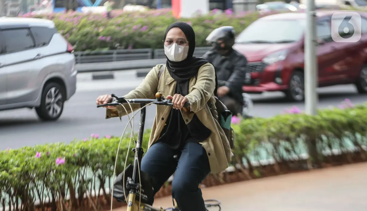 Warga melintas memakai masker untuk melindungi diri dari debu di Jalan Sudirman,Jakarta, Selasa (15/8/2023). (Liputan6.com/Faizal Fanani)
