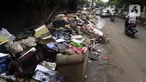 Tumpukan sampah terlihat menumpuk di sepanjang jalan pascabanjir mulai surut di kawasan Kembangan, Jakarta Barat, Minggu (5/1/2020). Pasca banjir yang melanda hampir di kawasan Jakarta mulai surut, tumpukan sampah terlihat di sepanjang jalan dari rumah-rumah warga. (Liputan6.com/Johan Tallo)