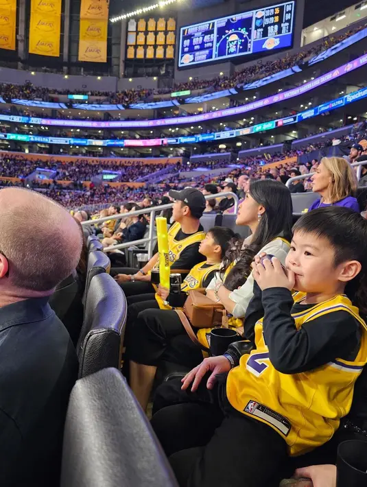 Tampil tak kalah kompak, kedua anak laki-laki pasangan ini juga mengenakan outfit serba hitam, baru menumpuknya dengan jersey Lakers. [Foto: Instagram/sandradewi88]