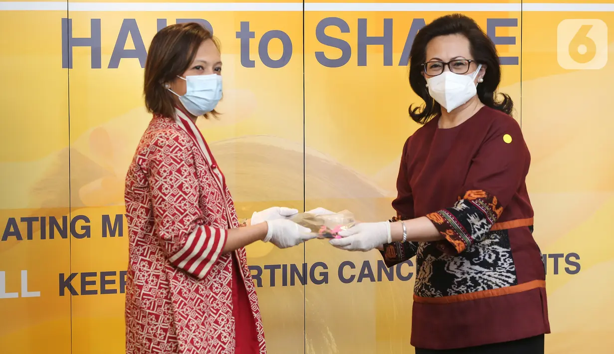 Direktur MRCCC Siloam Hospitals Semanggi Adityawati Ganggaiswari (kanan) menyerahkan rambut para donatur kepada Yayasan Kanker Indonesia (YKI) Novelia Rajaguguk (kiri) untuk pasien kanker pada Hair to Share di MRCC Siloam Hospitals Semanggi, Jakarta, Rabu (03/02/2021). (Liputan6.com/Fery Pradolo)