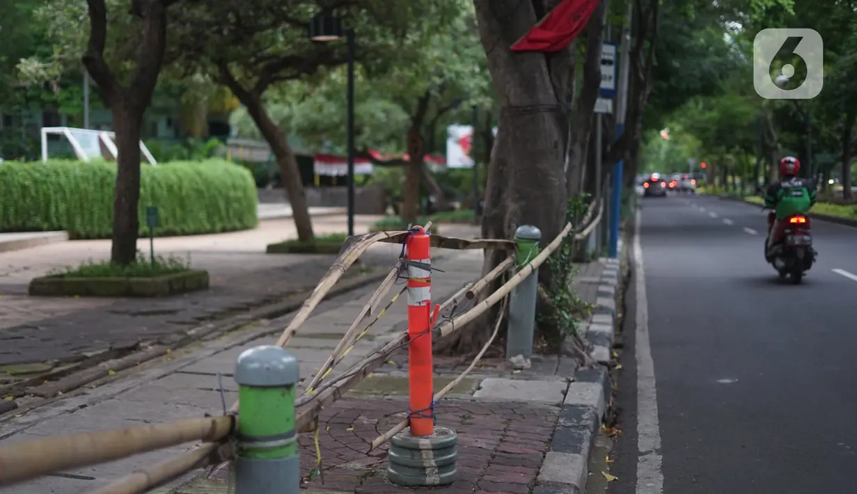 Bambu dipasang untuk menghalagi akses masuk Taman Menteng, Jakarta, Selasa (3/11/2020). Masih tingginya kasus covid-19 menyebabkan sejumlah fasilitas umum dan fasilitas sosial di Ibu Kota belum beroperasi normal sejak ditutup selama beberapa bulan lalu. (Liputan6.com/Immanuel Antonius)