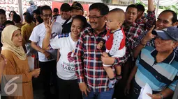 Djarot berfoto bersama warga sambil menggendong anak saat kegiatan pengobatan gratis di Pengadegan Barat, Pancoran, Jakarta, Kamis (26/1). Pengobatan gratis tersebut untuk memberikan penyuluhan mengenai hidup sehat. (Liputan6.com/Gempur M. Surya) 