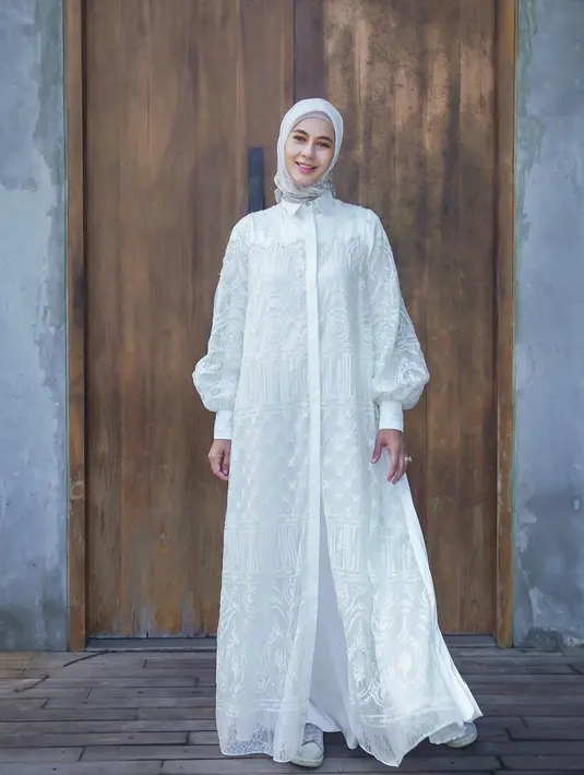 Penampilan anggun Paula dengan lace maxi dress berwarna putih yang dipadukan hijab dengan motif minimalis. [@paula_verhoeven]