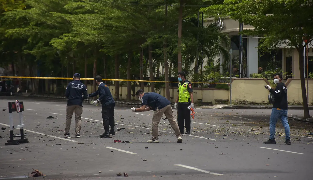 Polisi forensik memeriksa tempat kejadian setelah diduga bom meledak di dekat sebuah gereja di Makassar (28/3/2021). Sembilan orang terluka akibat kejadian tersebut. Empat di antaranya adalah jemaat gereja. (AFP/Indra Abriyanto)