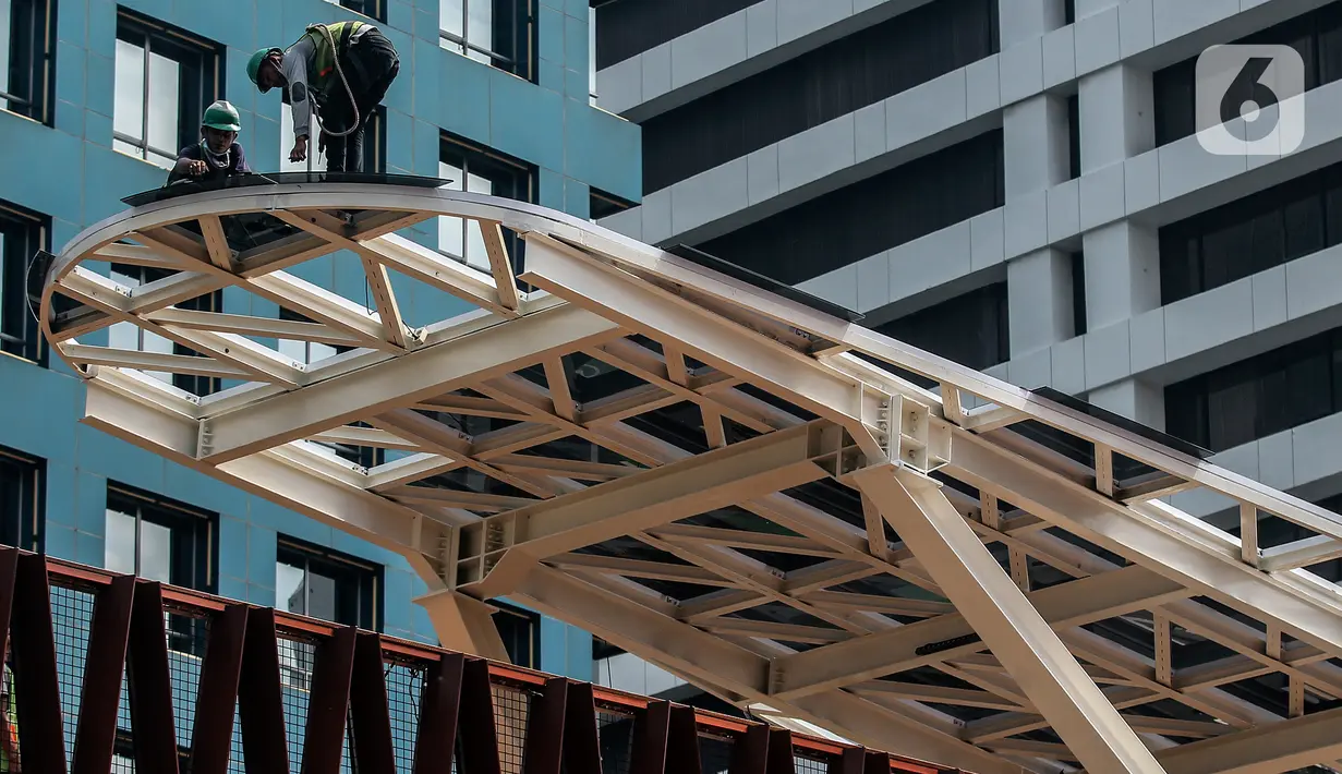 Aktivitas pengerjaan revitalisasi Jembatan Penyeberangan Orang (JPO) di Jalan Sudirman, Jakarta, Minggu (19/12/2021). JPO yang juga dilengkapi Anjungan Pandang Jakarta dan terintegrasi halte TransJakarta ini telah mencapai 95 persen dan akan dapat diakses pada akhir 2021. (Liputan6.com/JohanTallo)