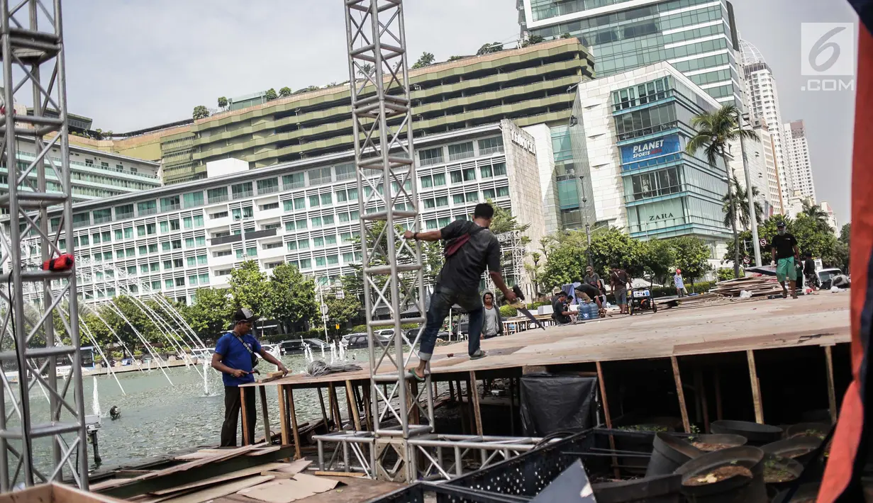 Pekerja menyelesaikan pembuatan panggung HUT ke-492 DKI di area Bundaran HI, Jakarta, Kamis (20/6/2019). Sejumlah artis Ibu Kota akan menghibur dalam peringatan HUT ke-492 DKI Jakarta. (Liputan6.com/Faizal Fanani)