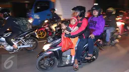 Pemudik bersepeda motor yang membawa anak kecil terlihat melintas jalur Pantura, Jawa Barat, Jumat (1/7). Masih banyak pemudik dengan sepeda motor yang nekat membawa anak kecil dan melebihi kapasitas muatan. (Liputan6.com/Angga Yuniar)