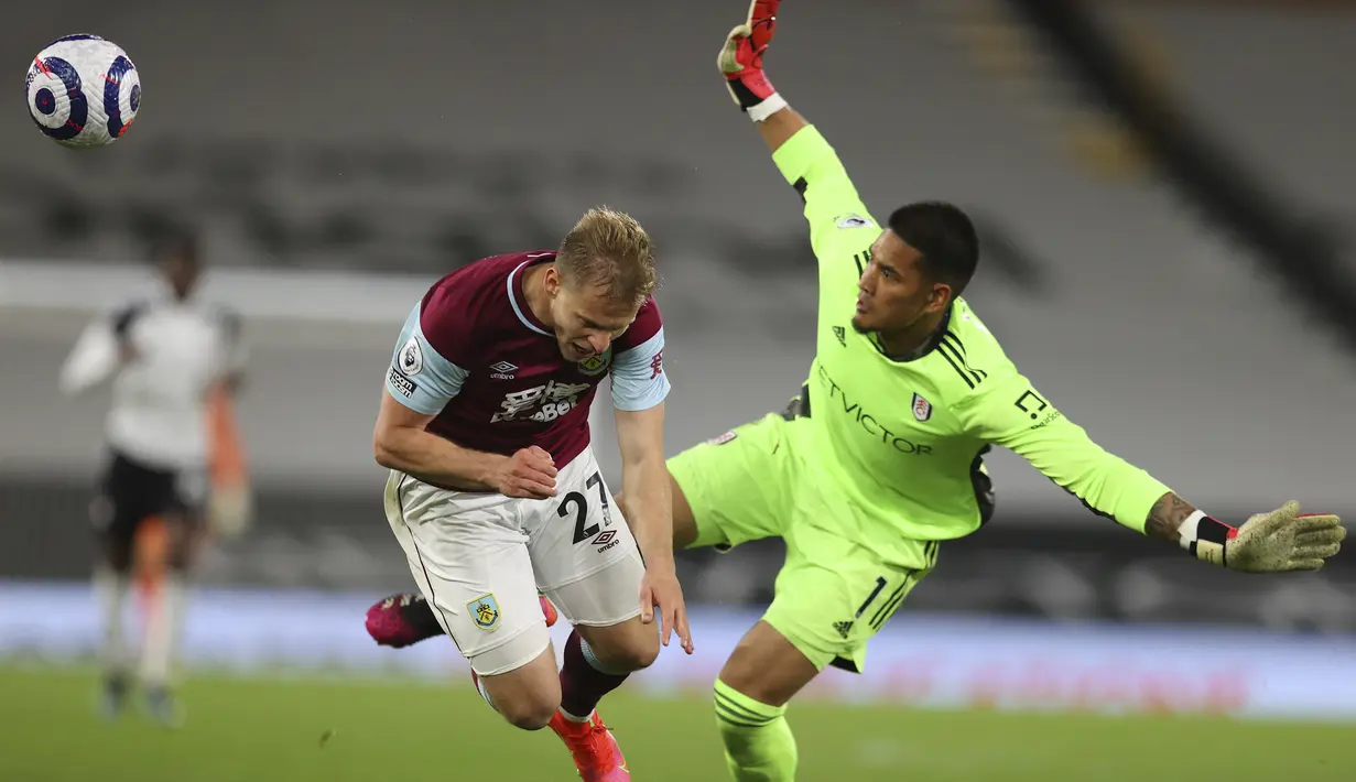 Kiper Fulham, Alphonse Areola (kanan) berhasil menghalau bola dari ancaman striker Burnley, Matej Vydra dalam laga lanjutan Liga Inggris 2020/2021 pekan ke-35 di Craven Cottage Stadium, London, Senin (10/5/2021). Fulham kalah 0-2 dari Burnley. (AP/Catherine Ivill/Pool)
