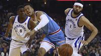 Ekspresi pemain Sacramento Kings, Skal Labissiere (tengah) saat berebut bola dengan dua pemain Warriors  pada laga NBA basketball game di Golden 1 Center, Oakland, California, (16/3/2018). King menang 98-93. (AP/Ben Margot)