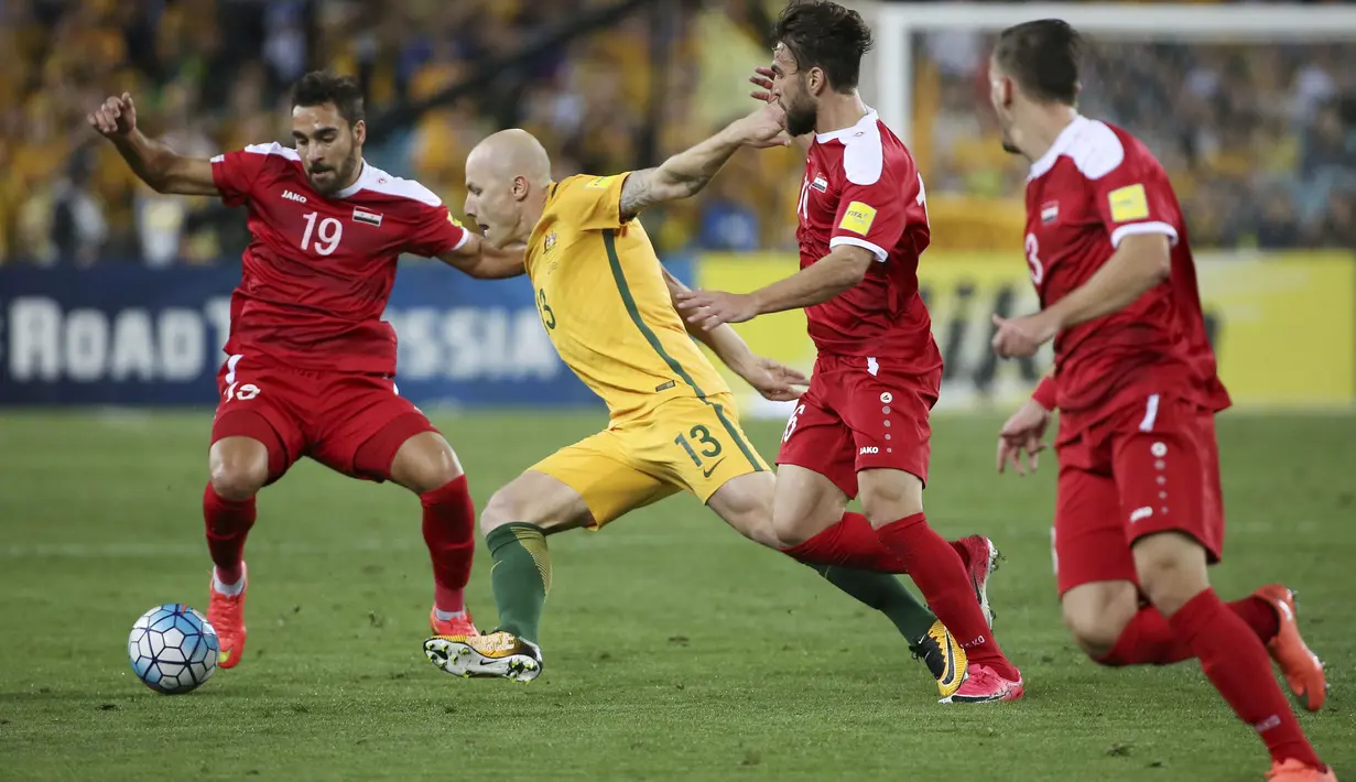 Aksi pemain Australia, Aaron Mooy (2kiri) berusaha melewati adangan pemain Suriah pada laga kualifikasi Piala Dunia 2018 di  Sydney (10/10/2017). Australia menang 2-1 pada leg kedua tersebut. (AP/Rick Rycroft)