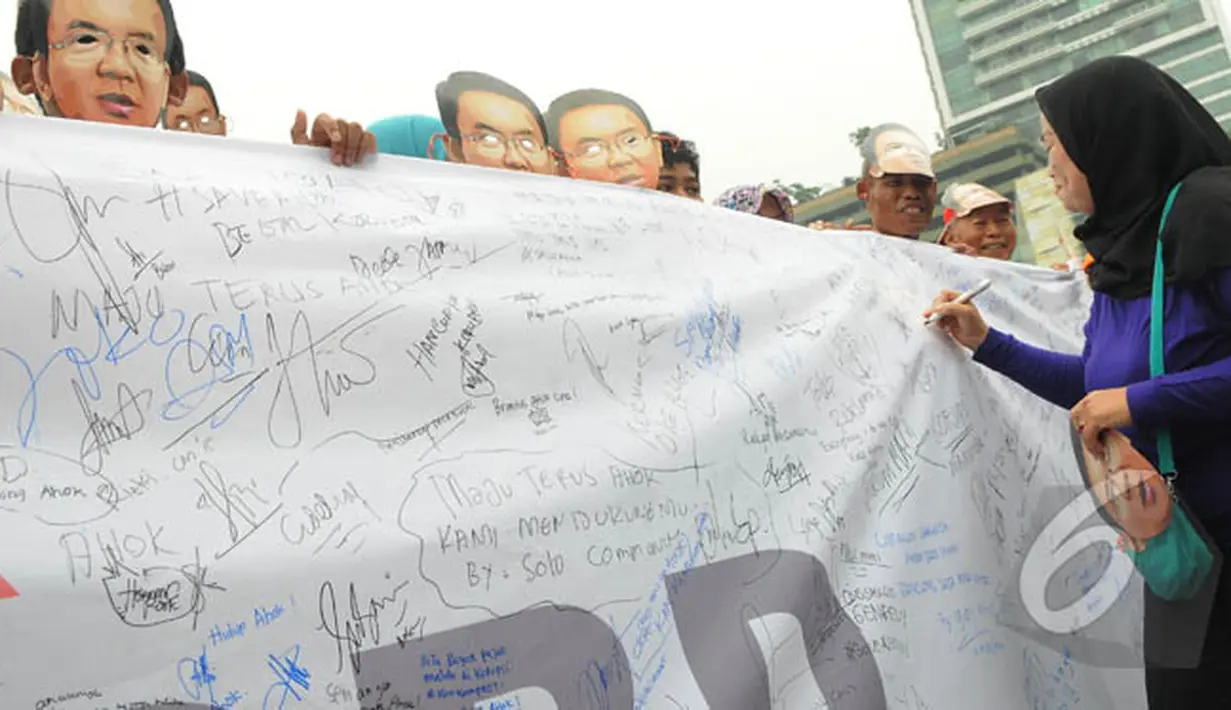 Seorang wanita membubuhkan tandatangannya saat aksi 'Lawan Begal APBD' di Bundaran HI, Jakarta, Minggu (1/3/2015). Aksi mereka sebagai bentuk dukungan kepada Ahok yang ingin membongkar dana siluman di Pemprov DKI (Liputan6.com/Herman Zakharia)