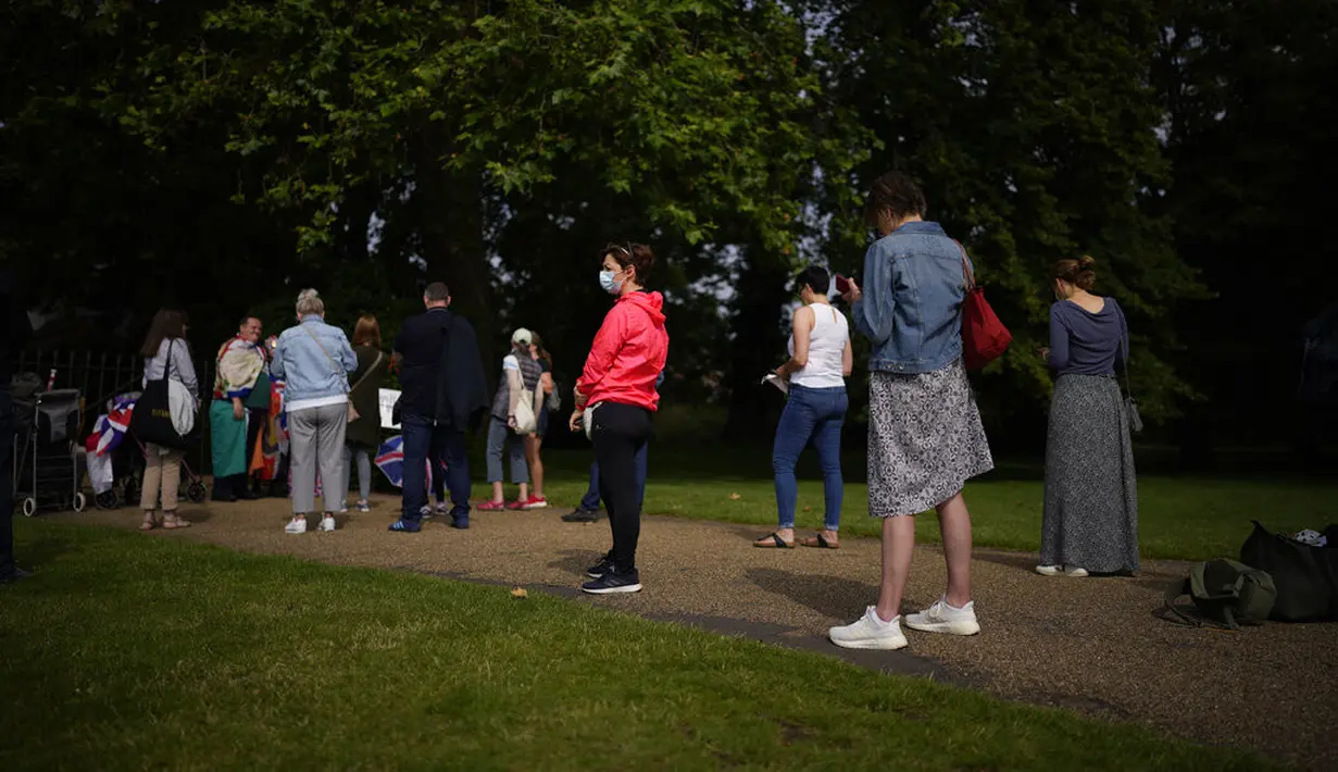 Orang-orang mengantre untuk melihat patung Diana, Princess of Wales, sehari setelah pembukaannya, di Taman Sunken di Istana Kensington, London, Jumat (2/7/2021). (Jonathan Brady/Pool Photo via AP)